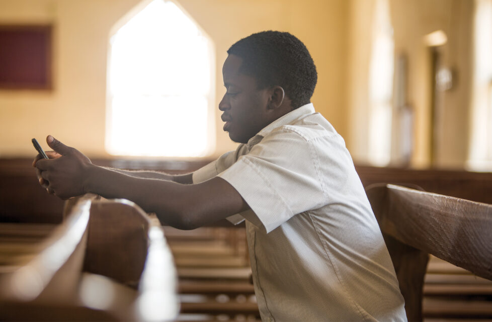 Nigerian Christian Mourns Sister Killed by Fulani Herdsmen A man sitting in church praying