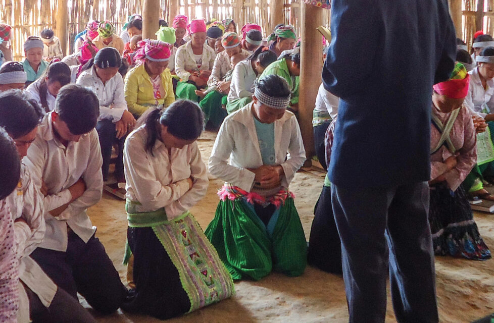 Persecuted Christians Know God is Greater than All Their Fears A Man standing in front of his congregation while they pray